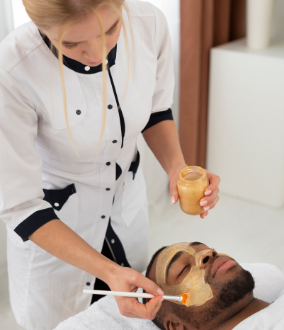 A woman applies an AquaJET facial mask to a man's acne scar skincare routine with a relaxing effect.